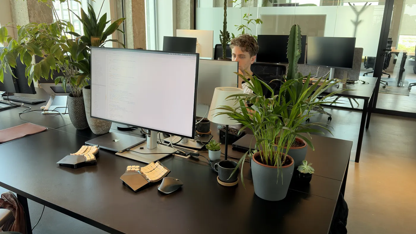 Max behind his monitor and plants in the new office